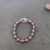 Purple beaded bracelet on dark texture.