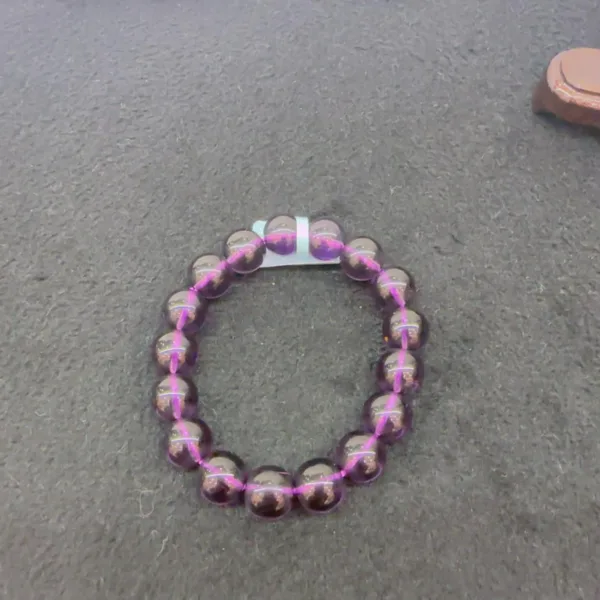 Purple beaded bracelet on dark texture.