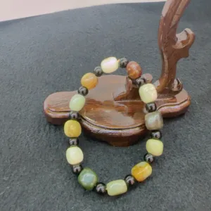 Multi-colored stone bracelet on wooden display stand.