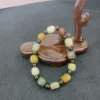 Multicolored beaded bracelet on wooden stand.