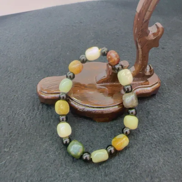 Multicolored beaded bracelet on wooden stand.