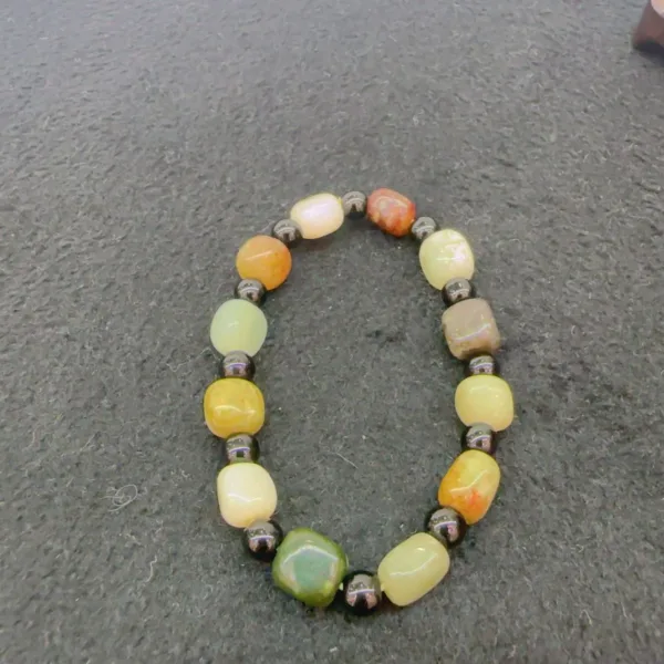 Multicolored beaded bracelet on gray surface.