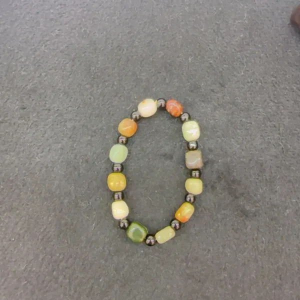 Multicolored beaded necklace on gray surface.