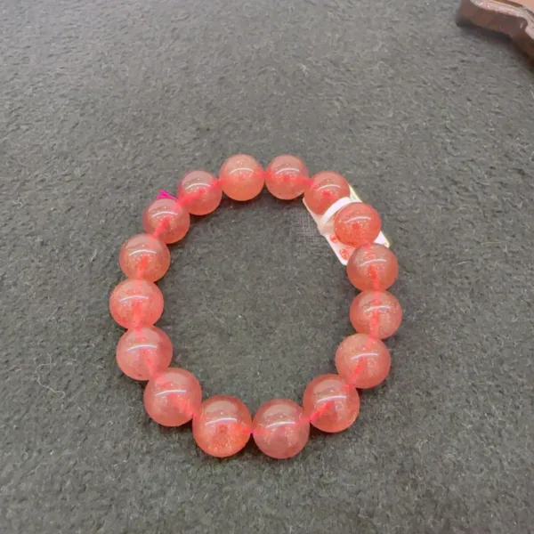 Sunstone bead bracelet on gray background.