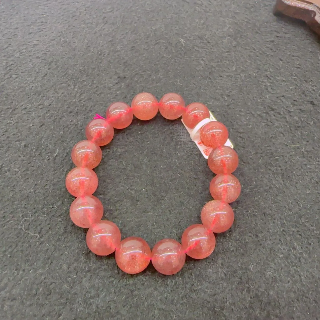 Sunstone bead bracelet on gray background.