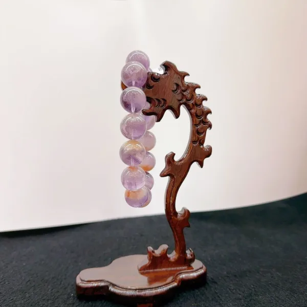 Carved wooden stand holding amethyst crystal spheres.