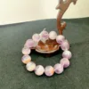 Amethyst crystal bracelet on wooden stand.