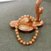 Wooden prayer beads and platform on gray surface.