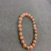 Orange beaded necklace on grey background