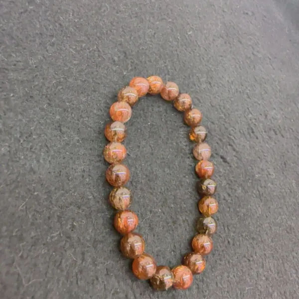 Orange beaded necklace on grey background