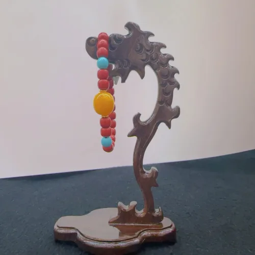 Wooden dragon sculpture with colorful beads.