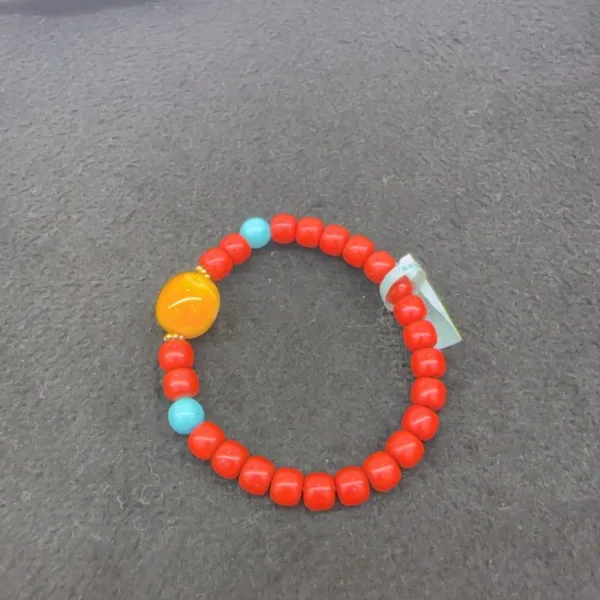 Colorful beaded bracelet on gray surface.