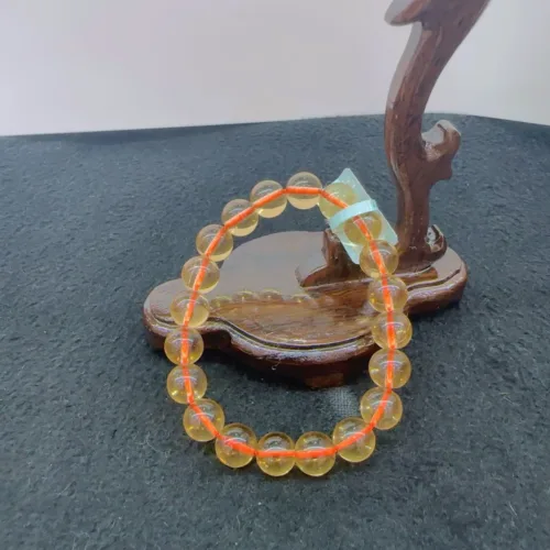 Amber beads bracelet on wooden display stand.