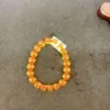 Orange bead bracelet on a dark surface.