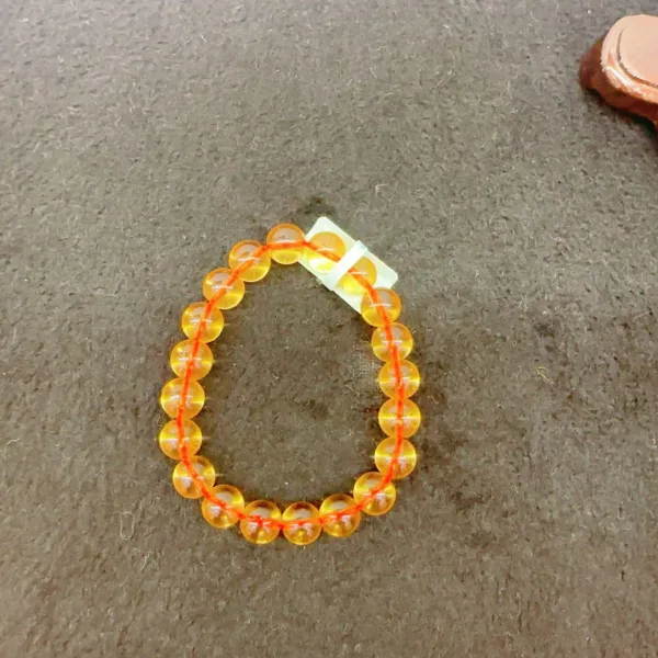 Orange bead bracelet on a dark surface.