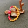 Colorful bracelet on wooden jewelry tree stand.