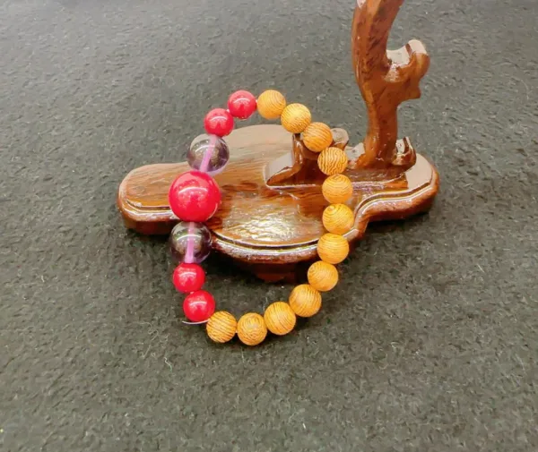 Colorful bracelet on wooden jewelry tree stand.