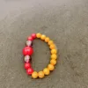 Colorful beaded bracelet on textured background.