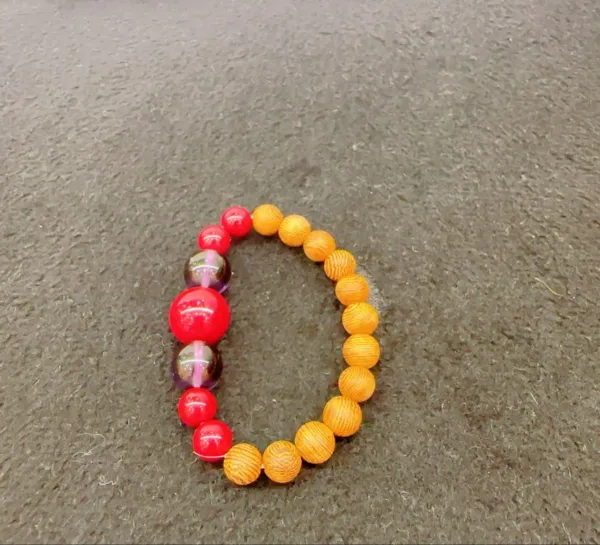 Colorful beaded bracelet on textured background.