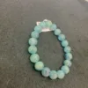 Aquamarine bead bracelet on dark surface.