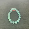 Aquamarine beaded bracelet on dark background.