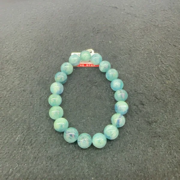 Aquamarine beaded bracelet on dark background.