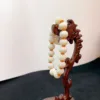 Wooden bead bracelet on carved seahorse stand.