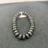 Faceted black bead bracelet on gray background.