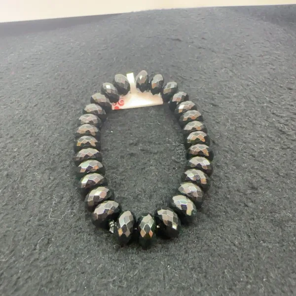 Faceted black bead bracelet on gray background.