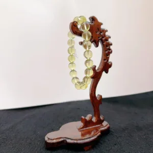Wooden stand holding a crystal bead necklace.
