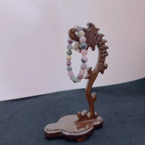 Beaded bracelet on wooden dragon stand.