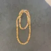 Amber bead necklace on dark surface.