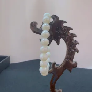 Carved wooden stand with pearl necklace.