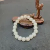 Pearl bracelet on wooden stand, gray background.