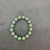 Iridescent beaded bracelet on gray background.