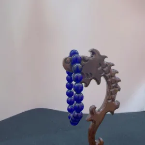 Carved wooden dragon with blue beads.