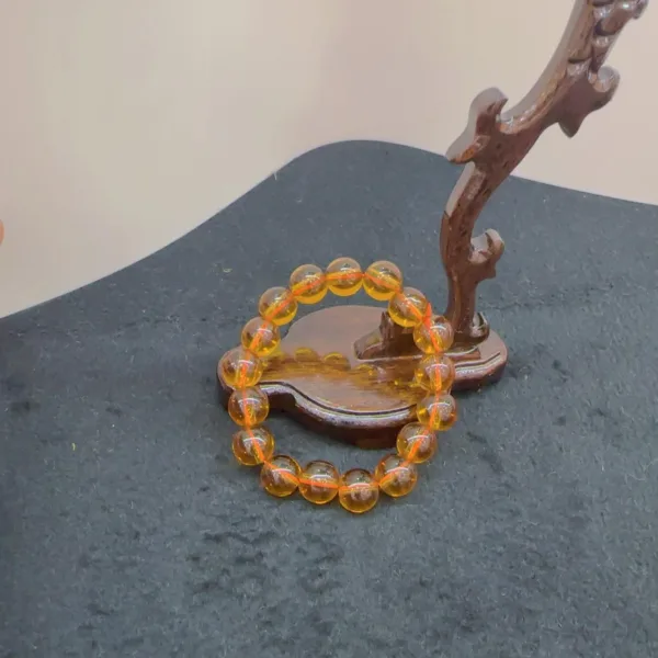 Amber bracelet on display with wooden stand.