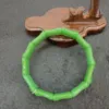 Green bracelet on wooden display.