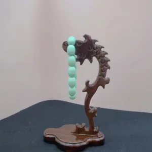 Carved wooden stand with jade beads.