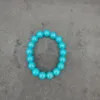 Blue beaded bracelet on gray background.