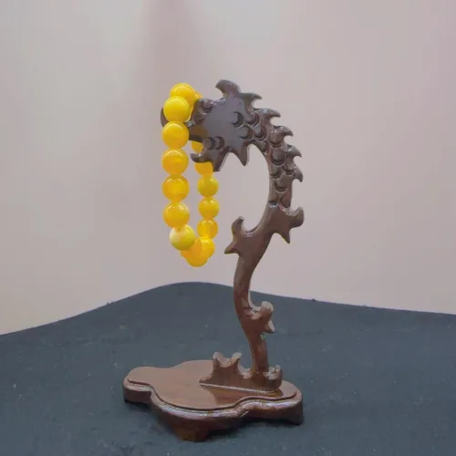 Wooden stand holding yellow beaded necklace.