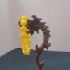 Yellow beaded bracelet on carved wooden stand.