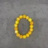 Yellow bead bracelet on gray background.