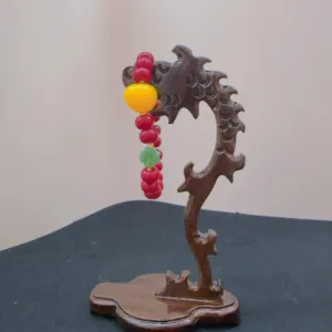 Carved wooden stand with colorful beads.