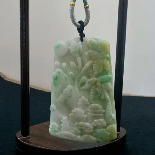 Carved jade sculpture with a decorative stand.