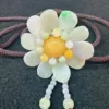 Jade flower pendant on braided cord necklace.