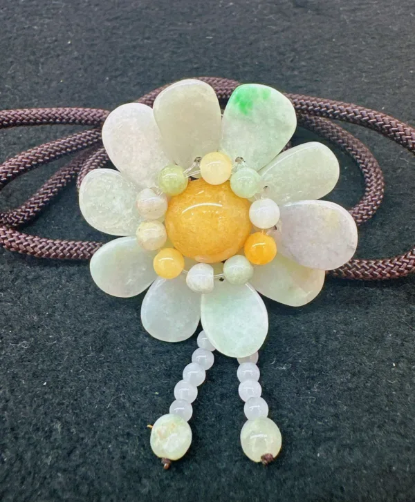 Jade flower pendant on braided cord necklace.