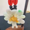 Handcrafted flower-shaped jade necklace on display stand.