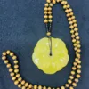 Yellow beaded necklace with flower pendant.