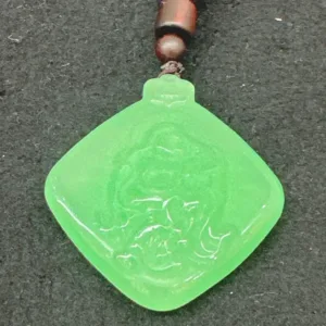 Green jade pendant with intricate carving.